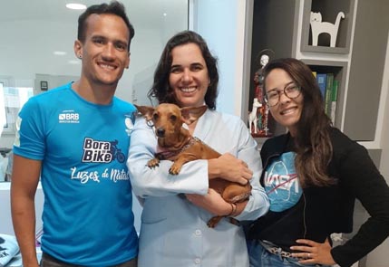 Veterinario dando carinho para cachorro apos tratamento